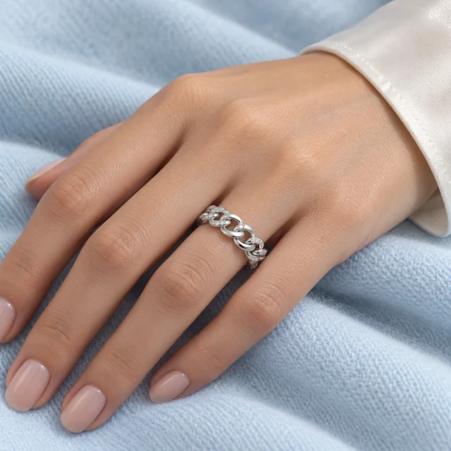 Liaison White-Gold Ring worn on the ring finger against pale blue fabric